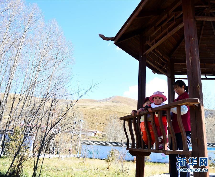 门源县东川镇尕牧龙下村村民在村里新建的文化广场休憩(10月25日摄).