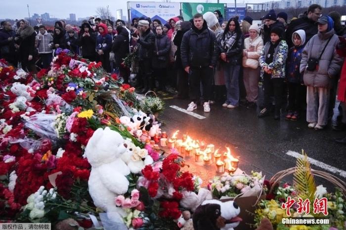 当地时间3月23日，俄罗斯当地民众前往遭受恐怖袭击的音乐厅，在围栏外面献上鲜花与玩偶，悼念遇难者。当地时间3月22日晚，俄首都莫斯科近郊克拉斯诺戈尔斯克市一音乐厅发生恐袭事件。截至目前，此次恐怖袭击已导致至少143人死亡，另有超百人受伤。图为民众在事发现场进行悼念。
